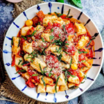 Soft homemade ricotta gnocchi served with butter, Parmesan, and fresh herbs.
