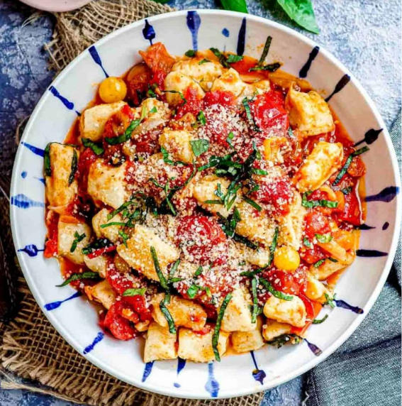 Soft homemade ricotta gnocchi served with butter, Parmesan, and fresh herbs.
