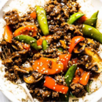 Homemade ground beef stir fry with colorful vegetables served over steamed rice in a bowl