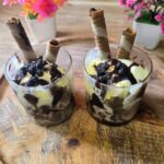Classic homemade ice cream sundae topped with chocolate sauce, whipped cream, colorful sprinkles, and a cherry