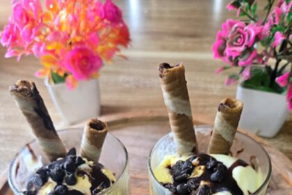 Classic homemade ice cream sundae topped with chocolate sauce, whipped cream, colorful sprinkles, and a cherry